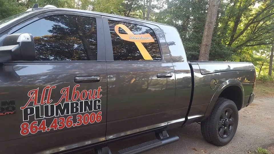 The pickup's door lettering: All About Plumbing, 864.436.3006, in red and black vinyl
