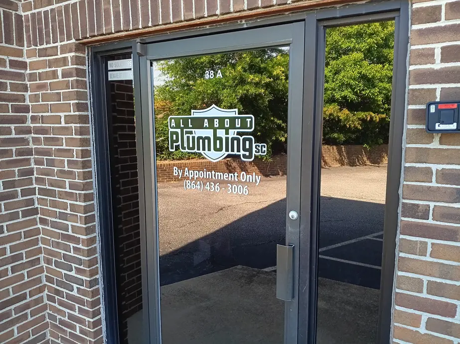 Glass office door with the All About Plumbing logo vinyl and a By Appointment Only notice